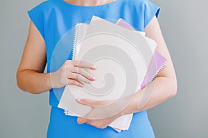 Closeup of woman hands arms holding work papers documents. Work from home or office. Secretary assistant on workplace. Student