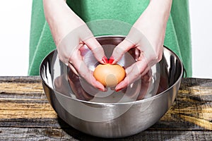 Closeup of woman hands cracking egg