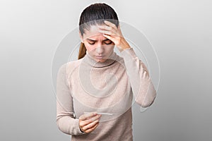 Closeup woman hands holding a glass thermometer with high temperature above thirty eight. coronavirus symptoms