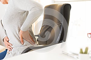 Closeup woman with hands holding her back pain. Office syndrome
