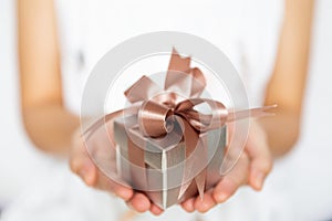 Closeup of woman hands holding a small gift box for special even