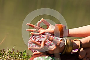 Closeup of woman hands in mudra gesture practice yoga meditation outdoor by the lake summer day