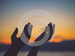 Closeup woman hands praying for blessing from god during sunset