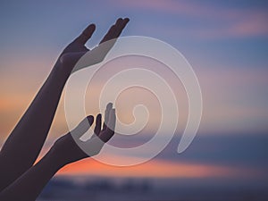 Closeup woman hands praying for blessing from god during sunset