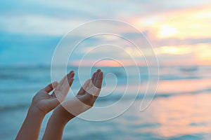 Closeup woman hands praying for blessing from god during sunset