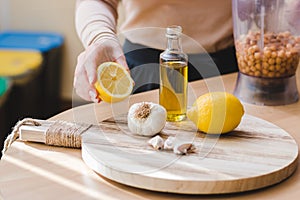 closeup woman hands preparing natural vegetarian food. homemade chickpeas hummus recipe