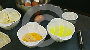 Closeup woman hands put separated yolk from broken raw egg into white bowl