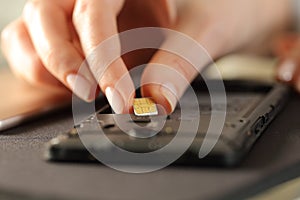 Closeup of woman hands putting sim card on smart phone