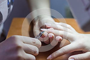 Closeup Of Woman Hands Receiving Nail Care Treatment By Professional Manicure Specialist