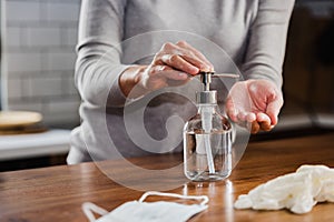 Closeup of woman hands using hand sanitizer liquid