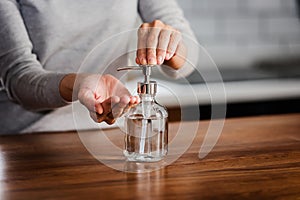 Closeup of woman hands using hand sanitizer liquid