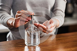 Closeup of woman hands using hand sanitizer liquid