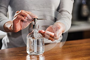 Closeup of woman hands using hand sanitizer liquid