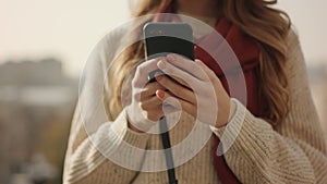 Closeup woman hands using phone outdoors. Unrecognizable girl holding cellphone.