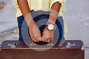 Closeup of woman hands holding vintage suitcase