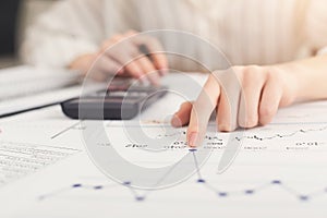 Closeup of woman hands working with documents and calculator