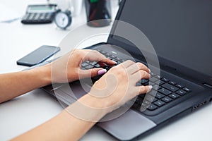 Closeup of woman hands working with laptop.