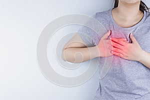 Closeup woman having heart attack or chest pain with red spot. Health care and medical concept