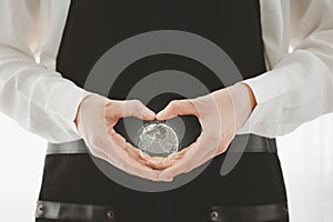 closeup woman heart shape hand with globe icon inside