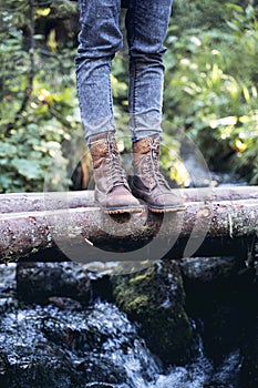Closeup of woman hiking boots on wooden bridge in the woods