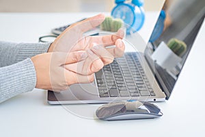 Closeup woman holding her hand pain from using computer long tim