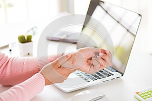 Closeup woman holding her wrist pain from using computer