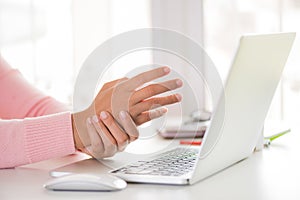 Closeup woman holding her wrist pain from using computer