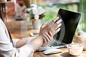 Closeup woman holding her wrist pain from using computer. Office syndrome hand pain by occupational disease