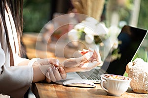 Closeup woman holding her wrist pain from using computer. Office syndrome hand pain by occupational disease