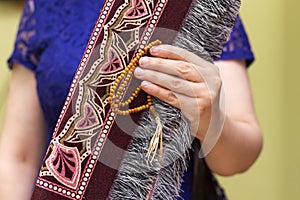 Closeup woman holding Muslim prayer mat or rug.