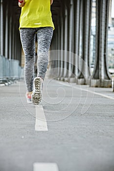 Closeup on woman jogger running on Pont de Bir-Hakeim bridge