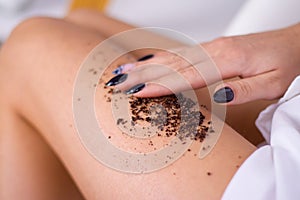 closeup woman legs with coffee massage scrub. Cosmetology, grooming, Spa cosmetic products, beauty and bikini concept