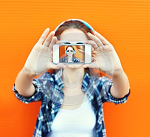 Closeup woman makes self-portrait on smartphone view screen