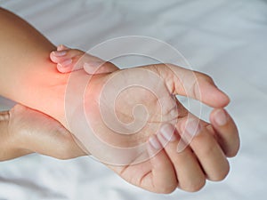 Closeup woman massaging her painful hand at home.