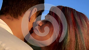 Closeup of woman with multicolored hair who is whispering secret to man in slowmo