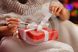 Closeup on woman opening Christmas present box