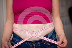 Closeup of woman pinching belly fat.