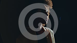 Closeup woman profile silhouette in dark background. Curly fashion model posing