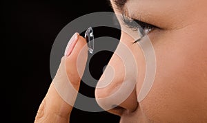 Closeup of woman putting contact lenses