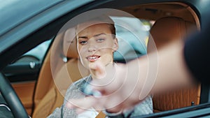 Closeup woman receiving car keys to new vehicle. Businesswoman sitting in car