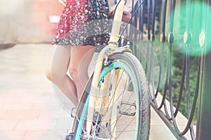 Closeup of woman riding by blue vintage city bicycle photo