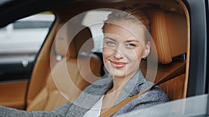 Closeup woman rolling down car window. Businesswoman sitting on front seat