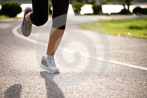 Closeup woman running towards on the road side. Step, run and outdoor exercise activities concept