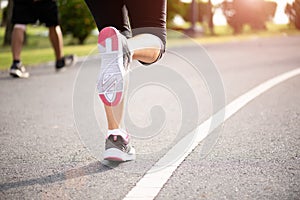 Closeup woman running towards on the road side. Step, run and outdoor exercise activities concept