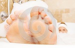 Closeup of woman`s feet covered with foam bubble bath