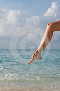 Closeup of woman`s foot on which sea water flows