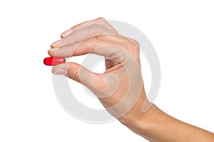 Closeup of woman& x27;s hand holding a half transparent red capsule