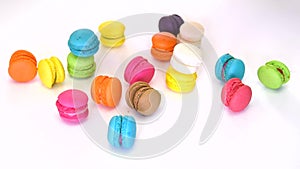Closeup of a woman's hand picking and aligning colorful macaron (macaroon) dessert food in fancy decoration on white isolated back