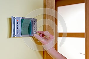 closeup of a womans hand setting the room temperature on a mode