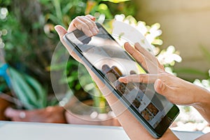 Closeup a woman`s hand is using a tablet to search and order food online